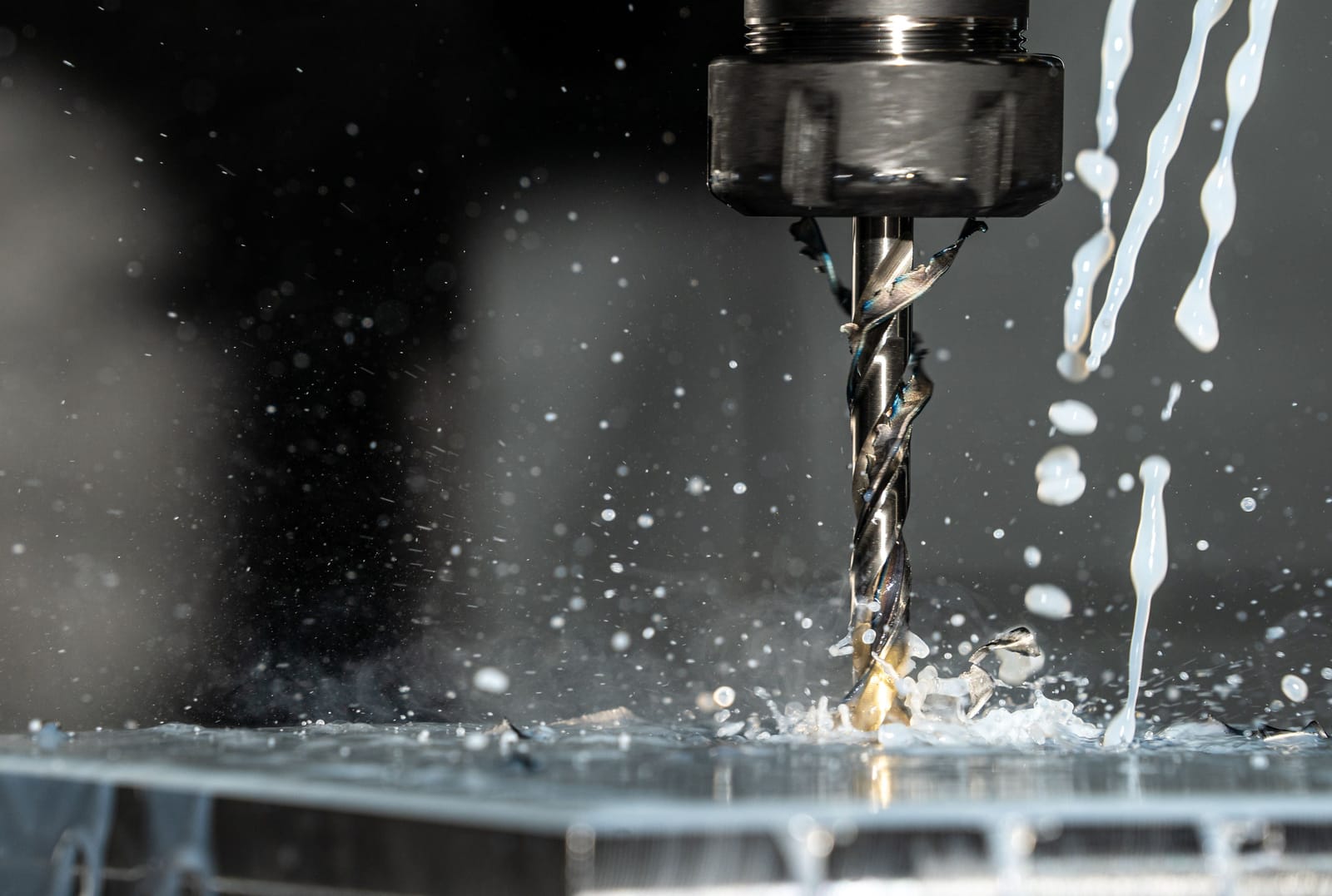 A CNC drill cutting metal, coolant spraying