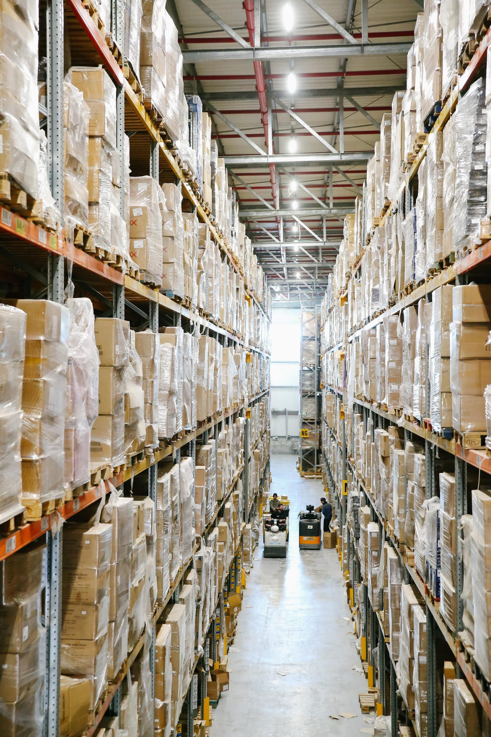A long warehouse aisle with shelves of boxed goods on both sides